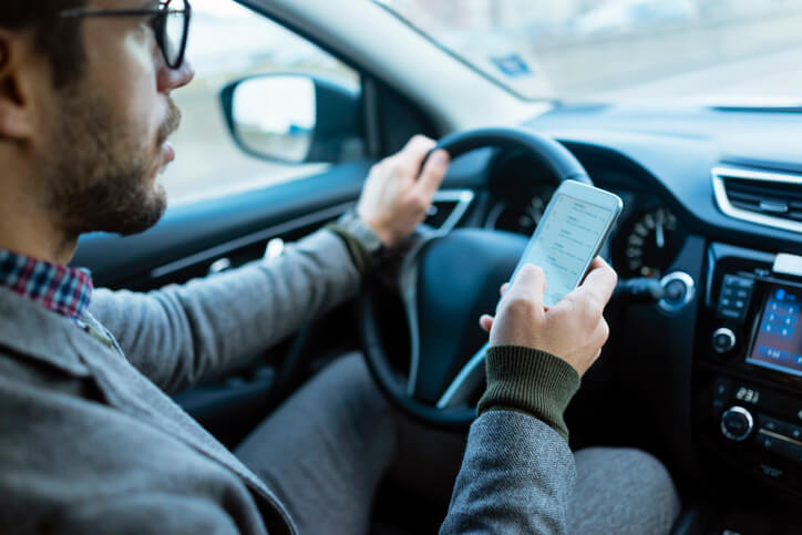 Man looking at his phone while driving