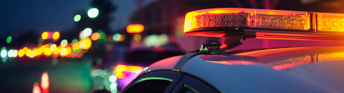 A police car stopping a vehicle at night.