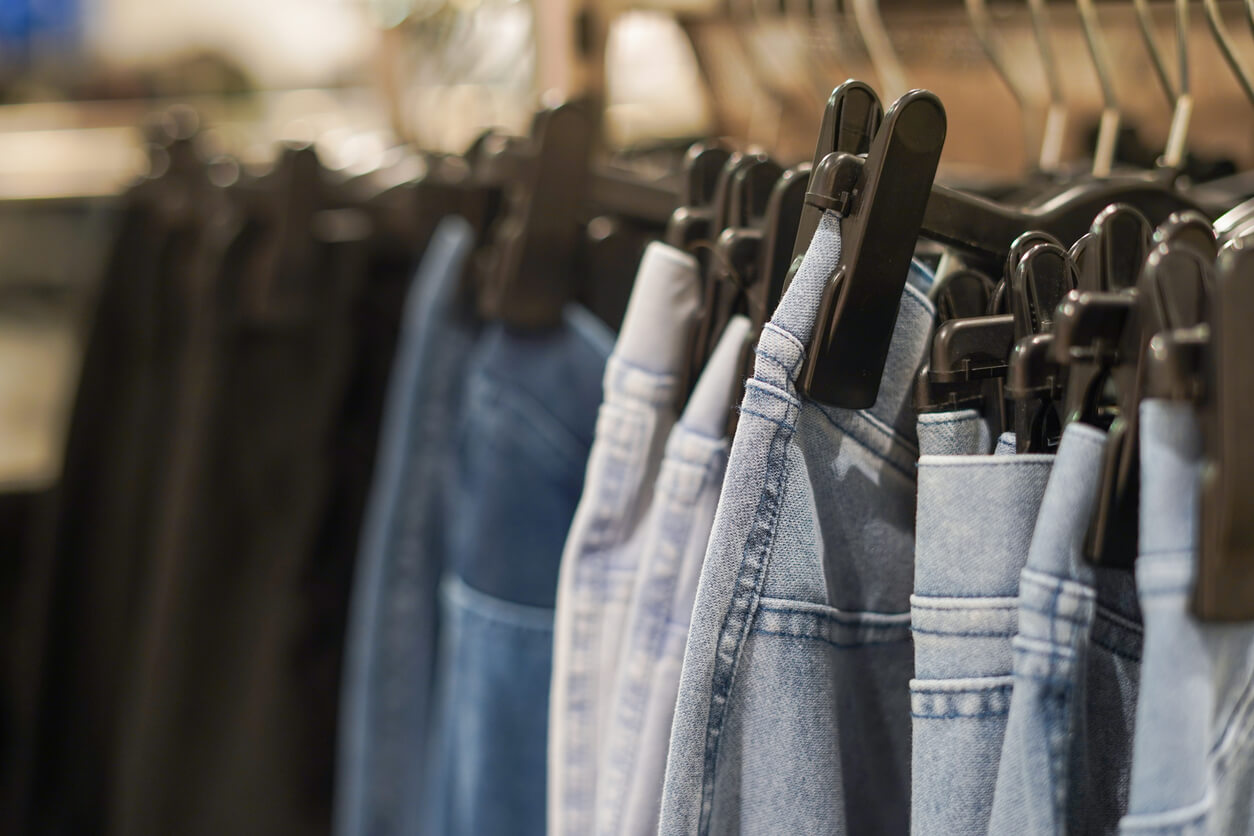 Row of jeans on the hanger in the shop, selective focus.