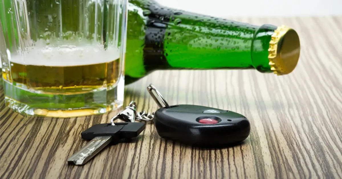 Llaves de auto junto a un vaso y una botella de cerveza, que representan el costo de un DWI en Houston
