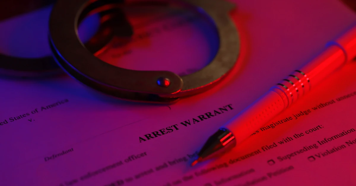Arrest Warrant and Handcuffs in Dramatic Lighting