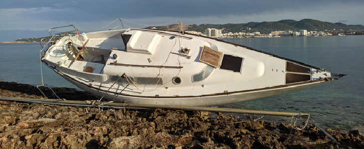 a boat flipped over on some rocks