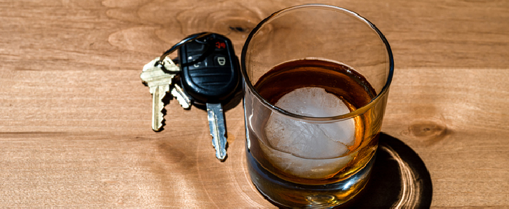 A glass of beer, with car keys next to it