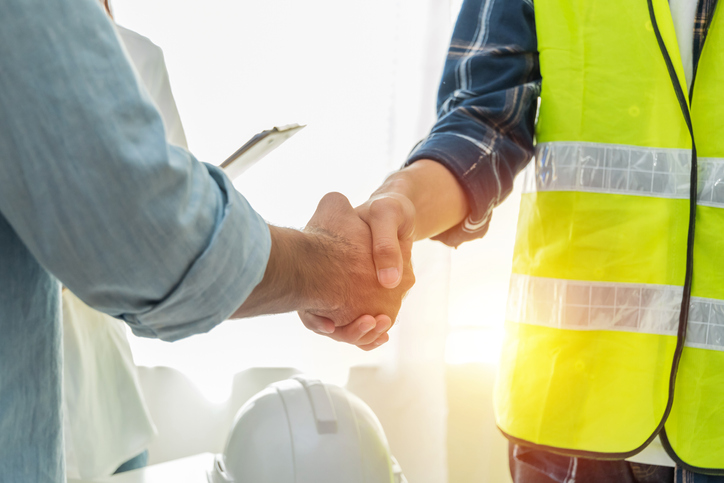 Construction worker shaking hands with attorney