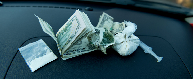 Drugs and cash on the dashboard of a car