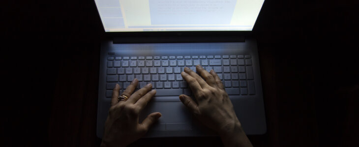 Female hands on a computer, working in the dark, at night causes much damage to the eyes