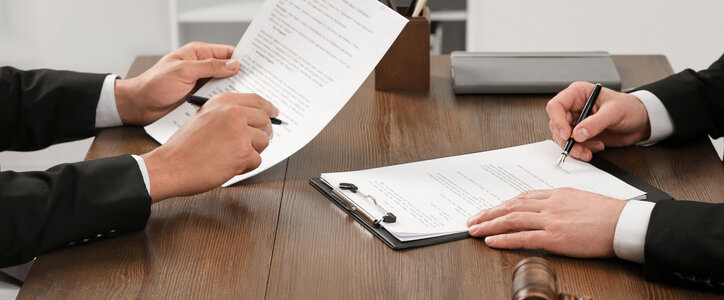 Law and justice. Lawyers working with documents at wooden table in office, closeup